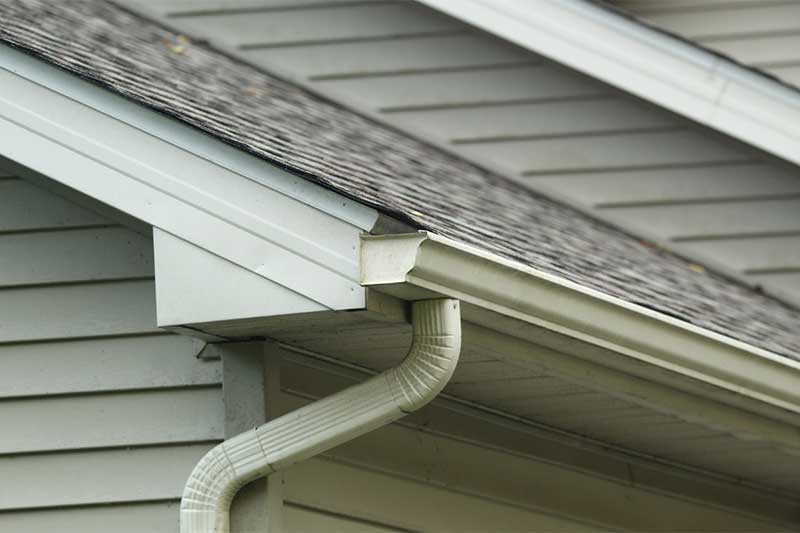 Closeup of a gutter system attached to the side of a home.