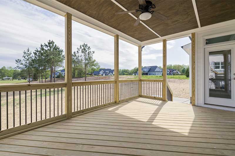 A newly constructed covered deck awaiting staining and finish on a newly constructed home.