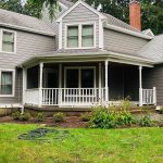 Backyard covered porch with hardscaping and gardens.